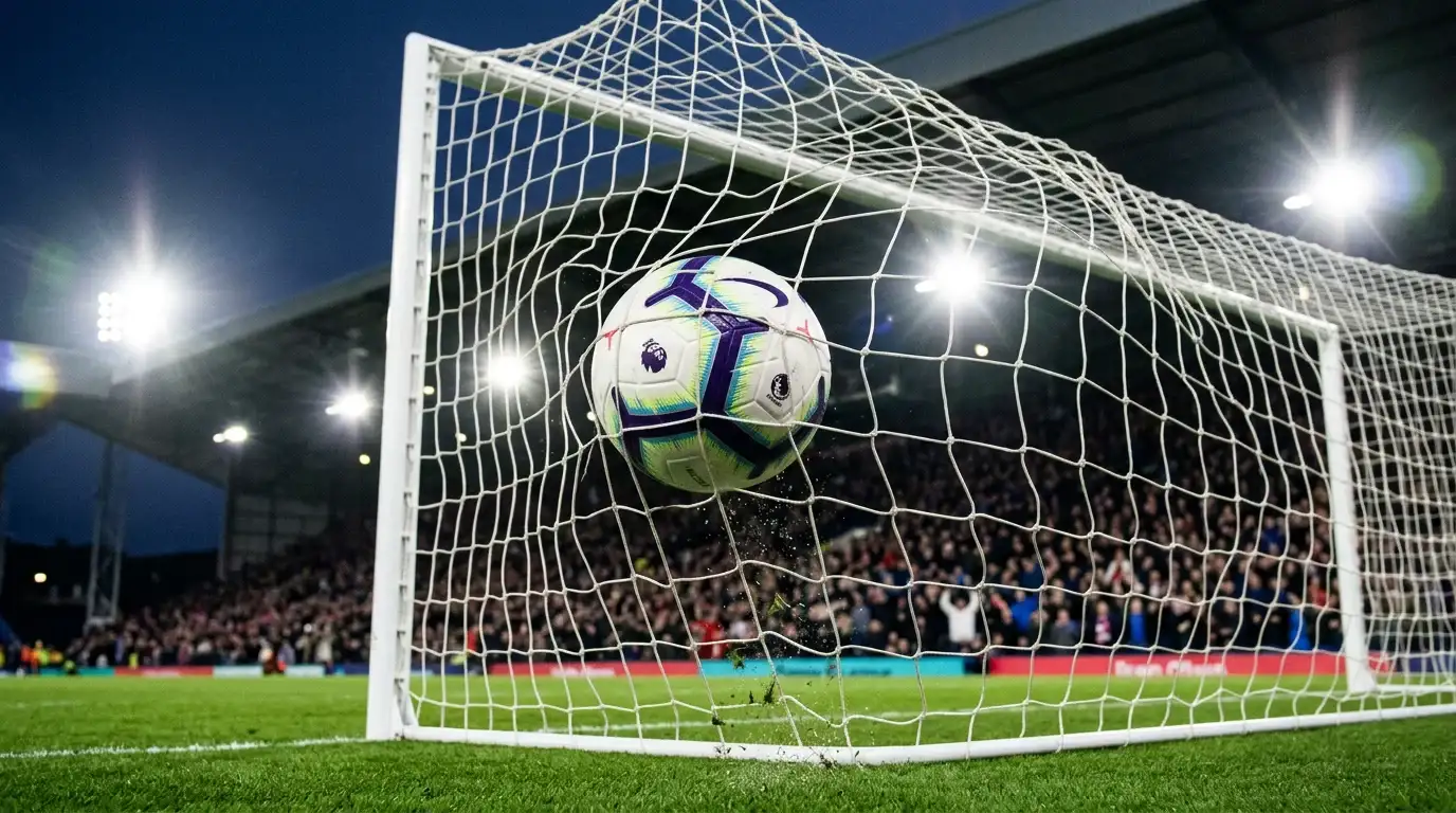 Delantero celebrando gol en estadio Premier League con marcador